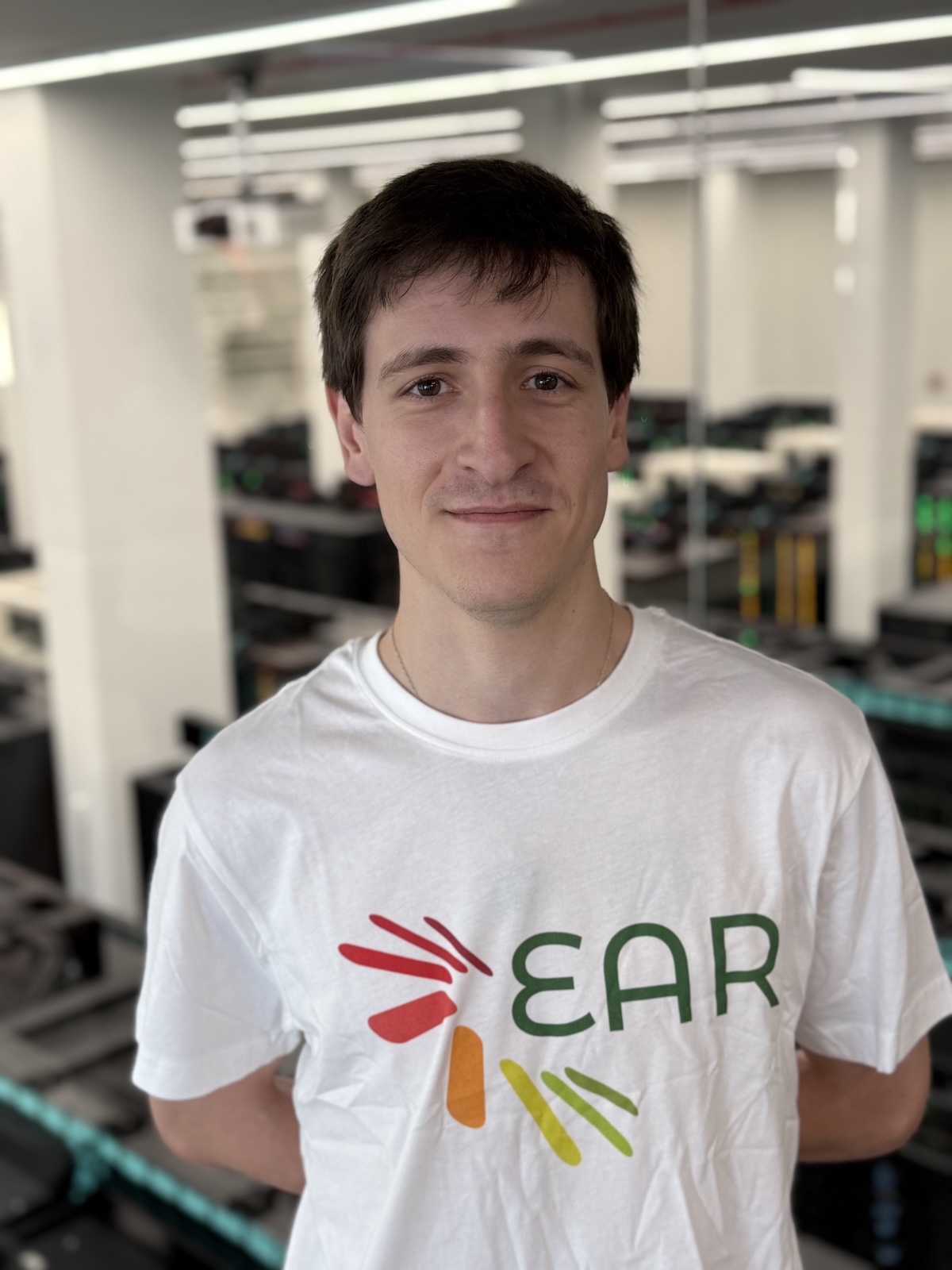 Profesional de Energy Aware Solutions (EAR) con camiseta corporativa en un entorno tecnológico e industrial