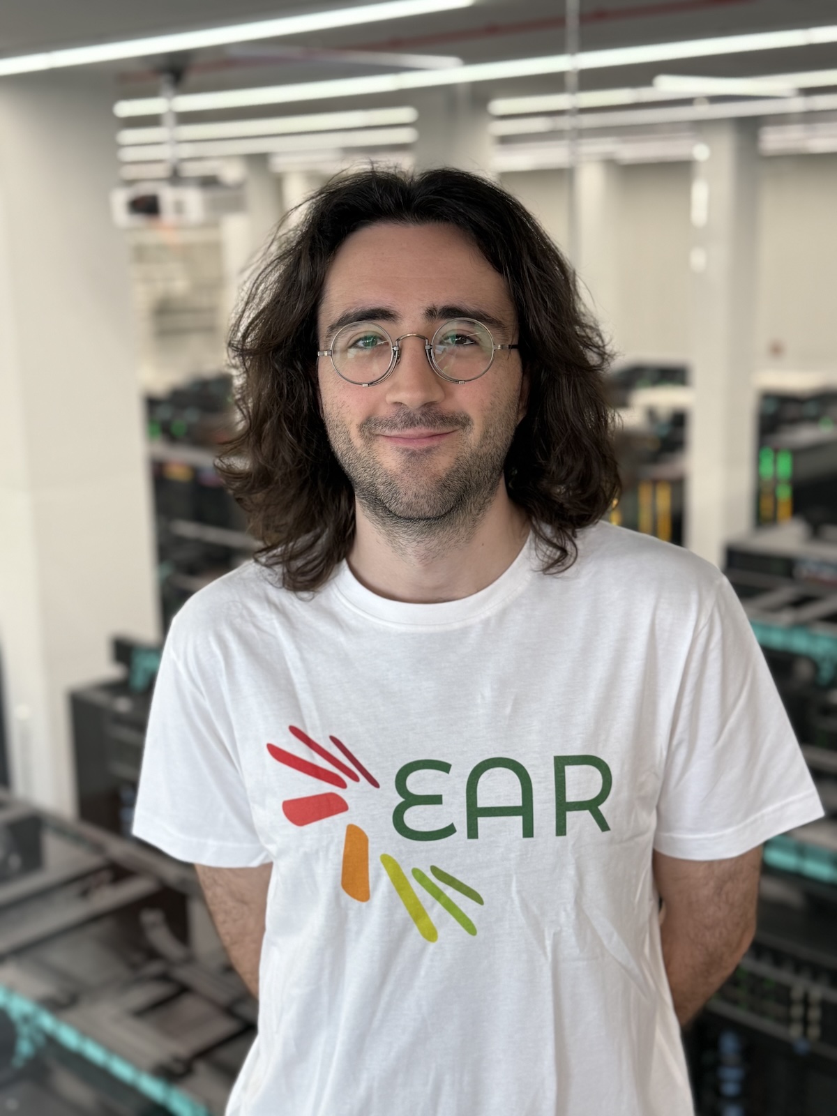 Profesional de Energy Aware Runtime (EAR) con camiseta corporativa en un entorno tecnológico e industrial